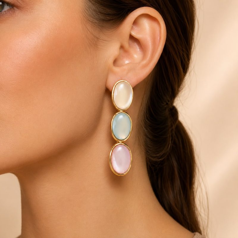 Beyaz, açık mavi ve pudra pembe oval detaylı altın çerçeveli sallantılı küpe.