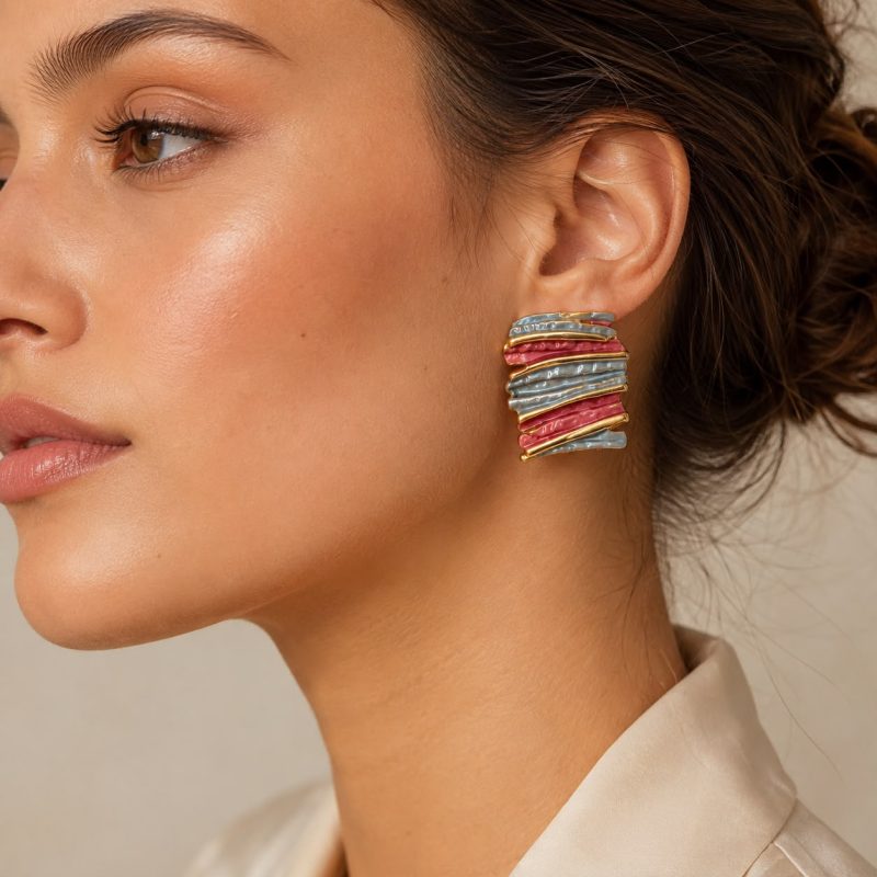Pembe, gri-mavi ve altın detaylı Rose Slate Wave Küpe modelin kulağında