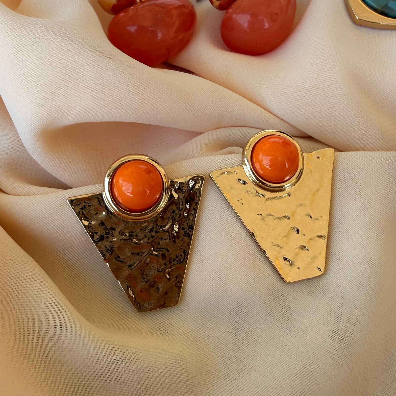 Modelin kulağında turuncu taşlı gold geometrik Solaris küpe